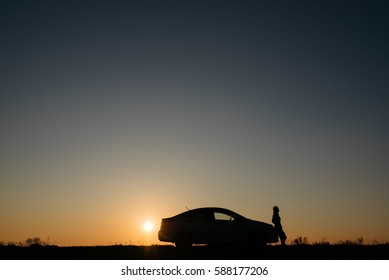 Silhouette Of Car And Girl At Sunset