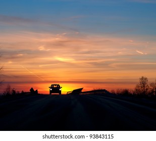 Silhouette Of Car On Bridge In Sunset