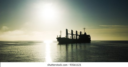 Silhouette Of The Cargo Ship Over The Sunrise