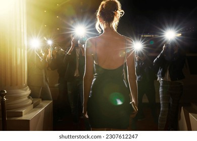 Silhouette of celebrity in black dress being photographed by paparazzi - Shutterstock ID 2307612247