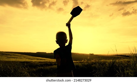 Silhouette Child Plays Superhero From Comics, Child Holds Hammer In His Hand. Winning Child. Childhood Dream, Boy Plays Mythological God Of Thunder, Lightning Hurricane Raises His Hand With Hammer Toy