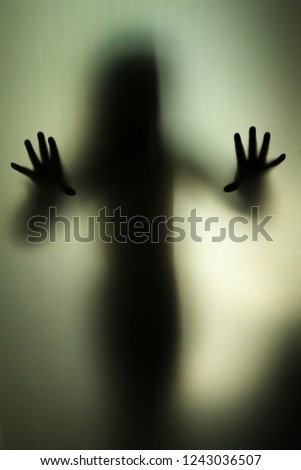 silhouette of child through a translucent window, creating a ghost-like effect