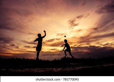 Silhouette Of Children Playing Paper Airplane At Sunset Invoke Childhood Memories