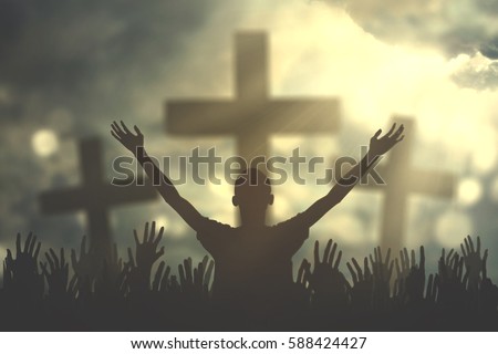 Silhouette of christian prayers raising hand while praying to the Jesus