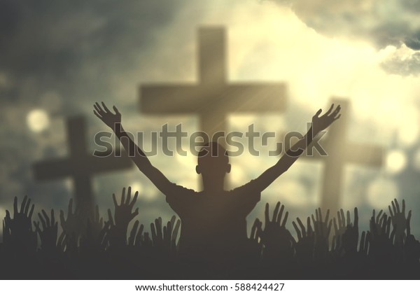 Silhouette of christian prayers raising hand while\
praying to the Jesus