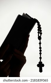 Silhouette Of A Christian Woman Reading The Bible With Prayer Beads.  Vietnam.  