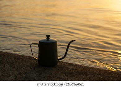 Silhouette Of A Coffee Kettle At The Lake With Sunlight.