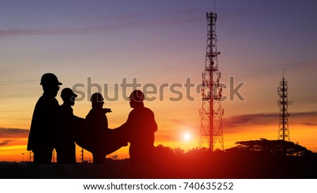 Silhouette construction engineer standing orders for worker team looking Telecommunication mast television at sunset, Teamwork concept