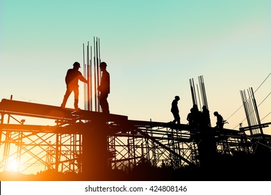 Silhouette construction industry engineer standing orders for worker
 team to work safety high ground over blurred background sunset pastel