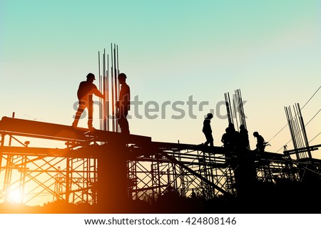 Silhouette construction industry engineer standing orders for worker
 team to work safety on high ground over blurred background sunset pastel