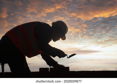 Silhouette construction mason worker bricklayer, construction worker laying bricks and building barbecue in industrial site. - Shutterstock ID 2020039877