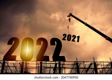Silhouette of construction worker with crane and cloudy sky for preparation of welcome 2022 new year party and change new business.