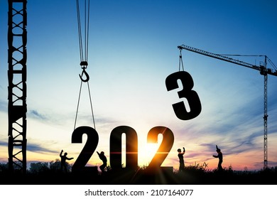 Silhouette of construction worker with crane and cloudy sky for preparation of welcome 2023 new year party and change new business.