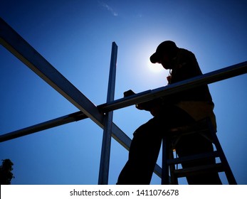 Silhouette Of A Construction Worker Working Under Hot Sun