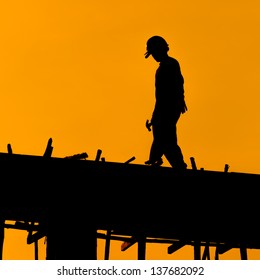 Silhouette Of Construction Workers On Scaffold Working Under A Hot Sun