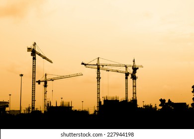 Silhouette Of Construction Workers On Scaffold Working Under A Hot Sun