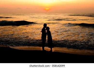 Silhouette Of  Couple About To Kiss On Beach At Sunrise