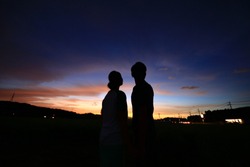 The Silhouette Of A Couple Against Magic Hour Sky