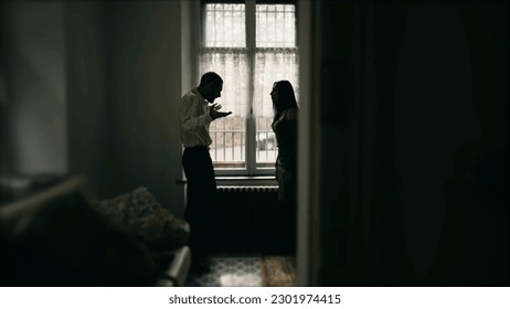 Silhouette of couple fighting each other, arguing and yelling at one another. Young man and woman shouting in anger. Candid behind closed doors - Powered by Shutterstock