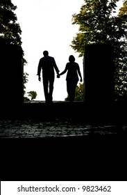 Silhouette Of A Couple Holding Hands Walking Away