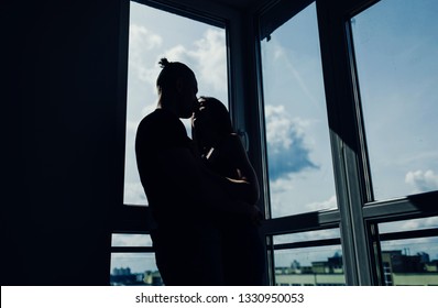 Silhouette of couple kissing in dark room  - Shutterstock ID 1330950053