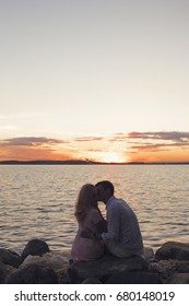 Silhouette couple kissing over sunset background