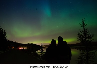 Silhouette Of A Couple Looking At The Northern Lights In Yukon, Canada