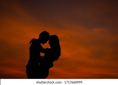 silhouette couple lover hugging in beauty sunset.