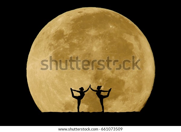 Silhouette of couple model doing yoga\
exercise on full moon\
background.