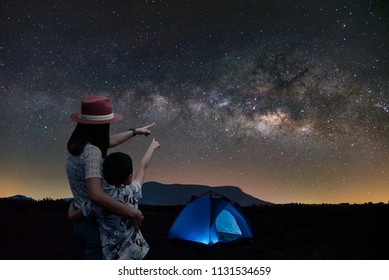 Silhouette Couple Mother And Son Asian Standing Together. Outdoor Camping Tent Looking At The Stars And The Milky Way In The Night. Long Exposure, Romantic And Happy.