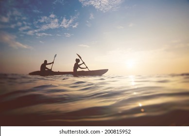 silhouette of a couple on a boat in the sea at sunset