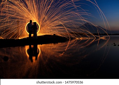 the silhouette of a couple with a steel wool background. steel wool is a photography technique using steel fibers that are burned and rotated using slow speed techniques