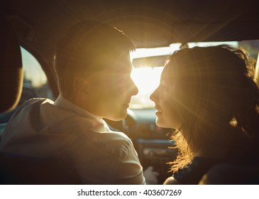 silhouette of couple in the sun for a moment before a kiss,wide angle in car 