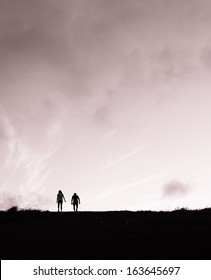 Silhouette Of Couple Walking Away
