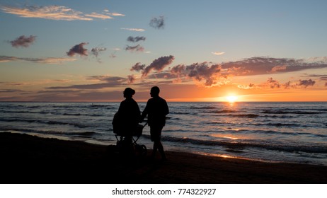 Silhouette of a couple walking on a beach - Powered by Shutterstock