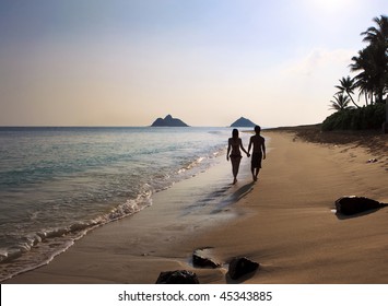 Silhouette Of A Couple Walking On A Hawaii Beach
