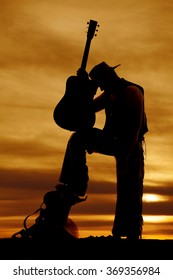 A Silhouette Of A Cowboy Holding On His Guitar With Is Head On It.