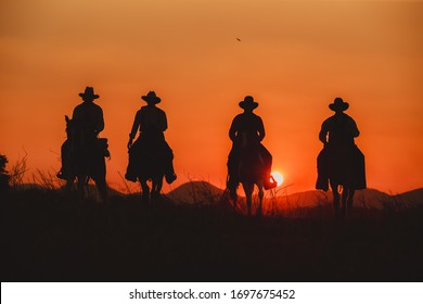 Silhouette the cowboy riding on a mountain with an yellow sky. - Powered by Shutterstock