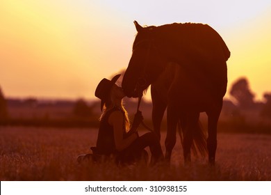 Silhouette of a cowgirl and horse. - Powered by Shutterstock