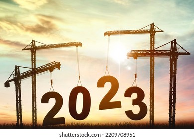 Silhouette of crane assembling 2023 number at the park with dusk sunlight background - Shutterstock ID 2209708951