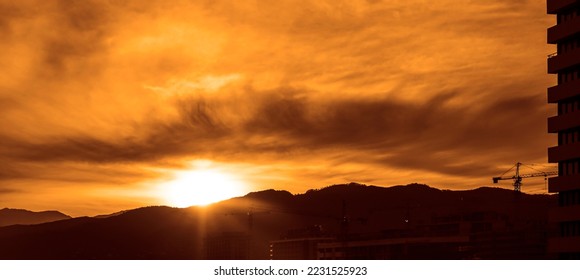 Silhouette Crane By Caucasus mountain Against Sky At Sunset. Sun set over hills landscape. Batumi, Georgia. 