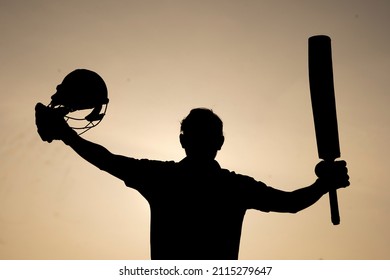 Silhouette of a cricketer celebrating after getting a century in the cricket match. Indian cricket players and sports concept. - Shutterstock ID 2115279647