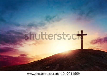 Silhouette cross on Calvary mountain sunset background. Easter concept