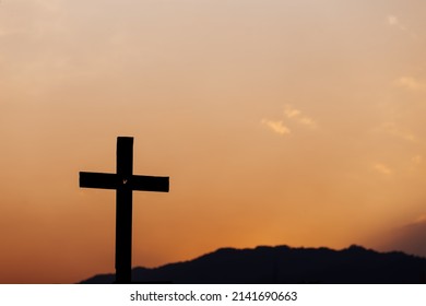 Silhouette of cross on mountain at sunset. concept of religion.