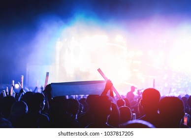 Silhouette Crowd Of Concert Stage Lights And People Fan Audience Raising Hands Or Glow Stick Holding In The Music Festival Rear View 