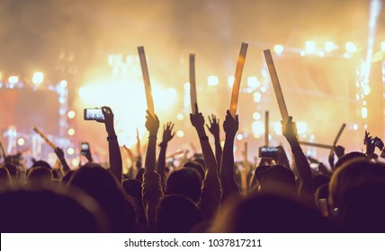 Silhouette Crowd Of Concert Stage Lights And People Fan Audience Raising Hands Or Glow Stick In The Music Festival Rear View 