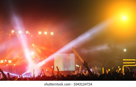 Silhouette Crowd Of Concert Stage Lights And People Fan Audience Raising Hands Or Glow Stick Holding In The Music Festival Rear View 