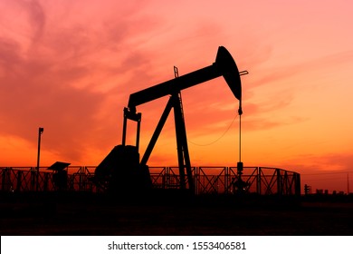 Silhouette Of Crude Oil Pump In The Oilfield At Sunset