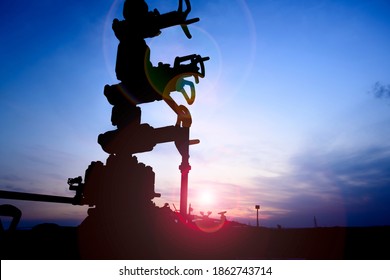 Silhouette Of A Crude Oil Well Head In The Oilfield At Sunset -underexposed 