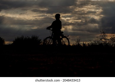 Silhouette of a cyclist in the light of the setting sun